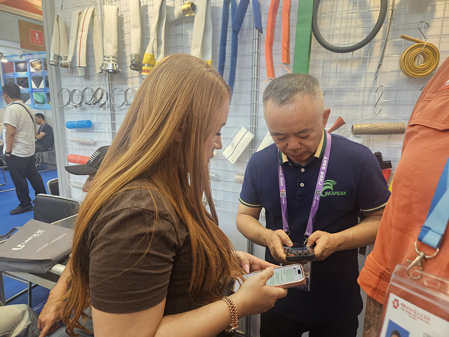 Checking product details with a visitor at the booth